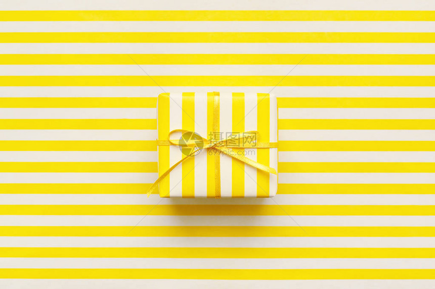 白色和黄色条纹包装纸上的黄色礼品盒卡片传单标牌或凭证的图片
