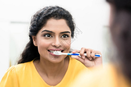 一个微笑的女人刷牙的特写镜头图片