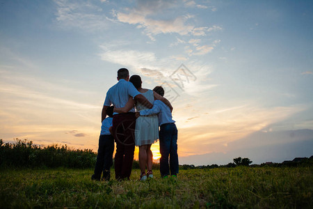 母亲父亲和两个儿子在田野中行走晒太图片