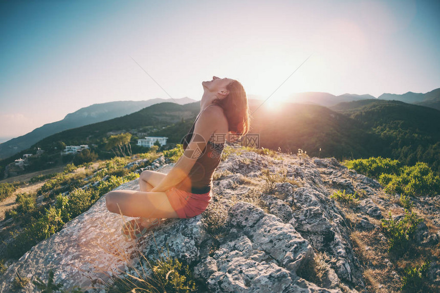 一个女孩坐在山顶上微笑着女人欣赏自然之美前往风景如画的地方反对天空的旅游黑发女图片