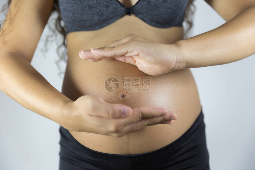 近距离摄影棚拍摄孕妇触摸肚子的镜头图片
