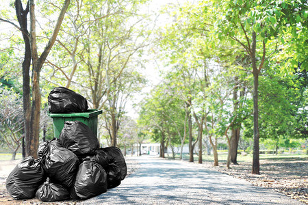 人行道旁的垃圾箱绿色回收和垃圾塑料袋图片