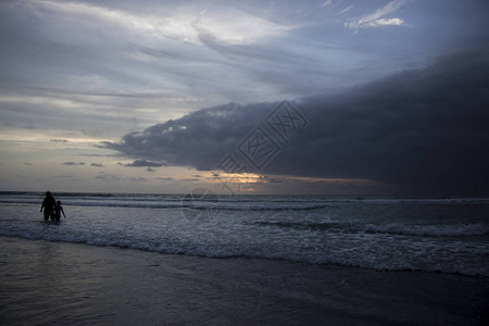 海滩上的黄昏天空与人的剪影图片