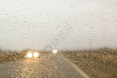 车子沿着秋路行驶挡风玻璃上的雨滴图片