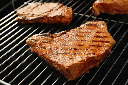 烧烤炉排上的新鲜烤肉牛排特写背景图片