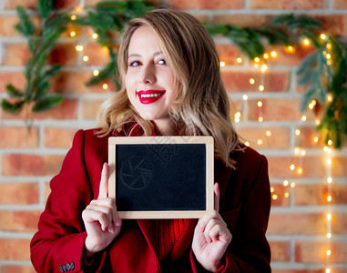 在圣诞节灯光下一个穿红色大衣有黑板的年图片