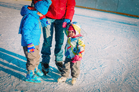 父亲有两个孩子男孩和女孩在冬天滑图片