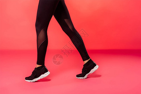穿着红色黑紧身裤行走的女运动员的裁剪图像图片