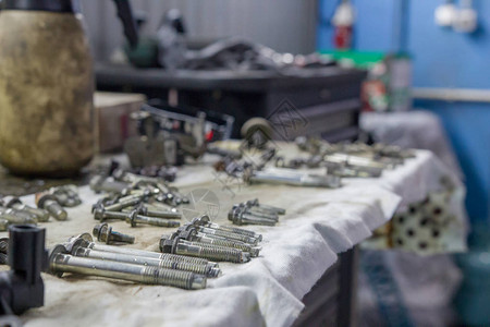 汽车修理厂的维修工桌上有很多螺栓和其他物品高清图片