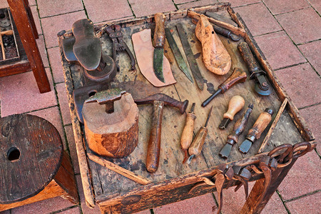使用手工制鞋工用旧工具在桌子上工作图片