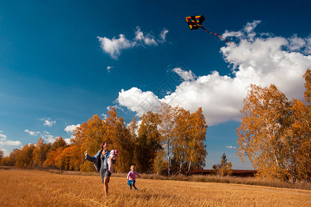 在温暖的秋日阳光明媚的日子里微笑享受大自然并玩风筝图片