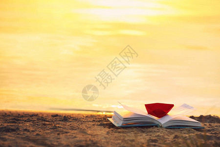 在海滩上用折纸船打开书图片