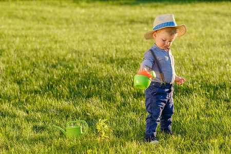 身戴草帽的幼儿男孩用水罐子图片