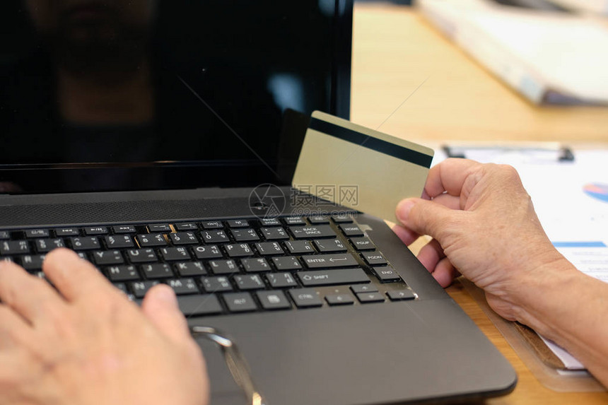 女人拿着信用卡使用电脑进行网上购物图片