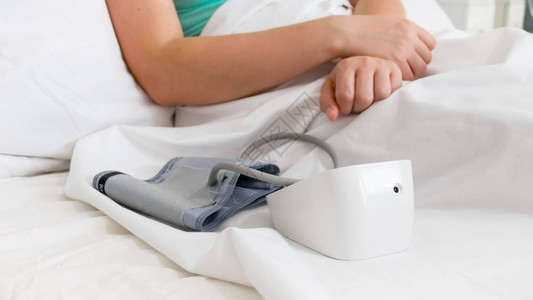 医院生病妇女床上数字血压监测器的近照图片