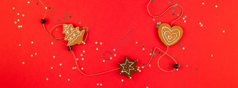 或圣诞装饰平躺顶视图圣诞假期庆祝手工装饰糖果星在红纸背景上闪发光模板图片