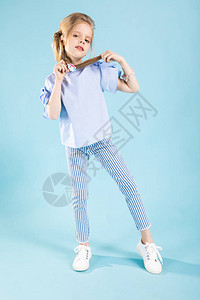 一个穿蓝色T恤条纹裤子和白运动鞋的少女图片