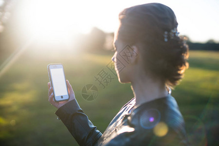 拿着智能手机朝太阳的女人图片