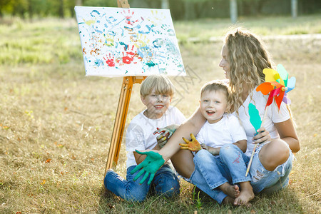 快乐的家庭年轻漂亮的母亲和她的孩子在户外玩得图片