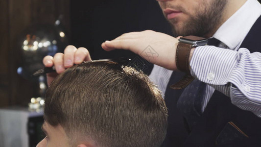 裁剪的专业理发师在他客户的头发上喷水图片