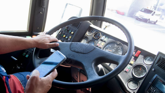 司机驾驶公共汽车时持智能手图片