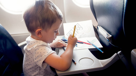 初体验飞行时在飞机上绘画的幼儿男背景