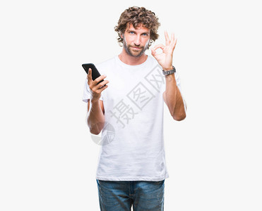 英俊的西班牙裔男子模特在孤立的背景下使用智能手机发送短信图片