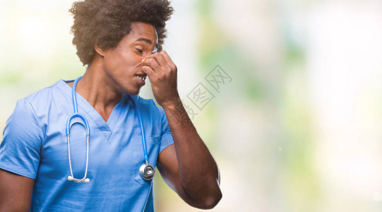 与世隔绝背景的非裔美国外科医生男子闻到一些臭味恶心难以忍受的气味图片