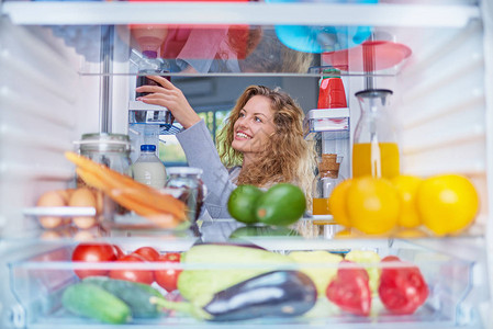 女人从冰箱里拿食物图片