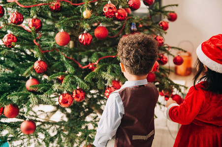 一群两个小孩在家里玩圣诞树在家图片