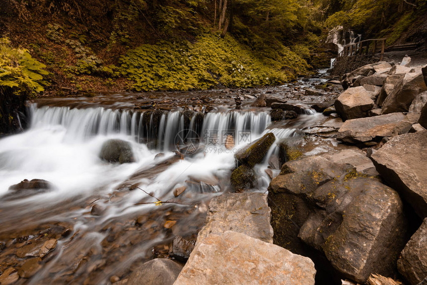 美丽的山瀑布有快速流水和岩石图片
