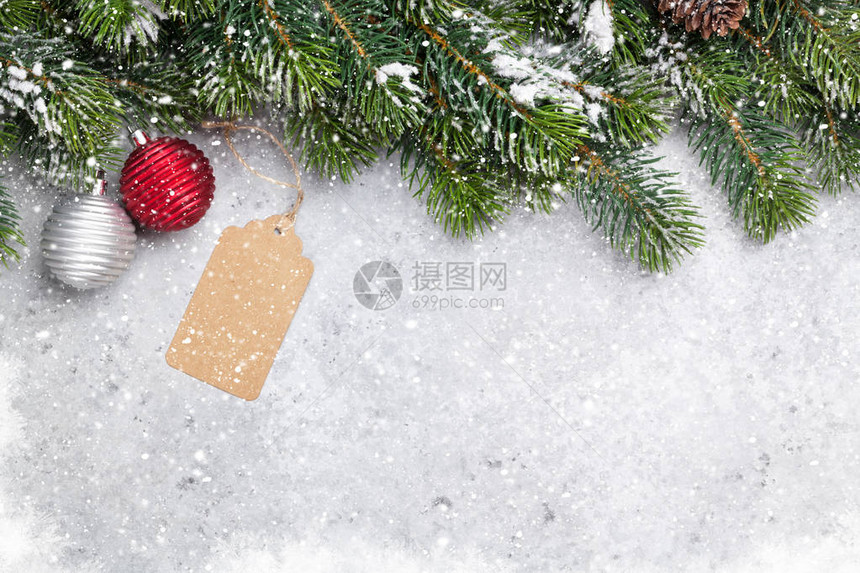 由雪和石本背景上布满了积雪和卷毛装饰的圣诞fir树枝您贺卡中带有文字空间的X图片