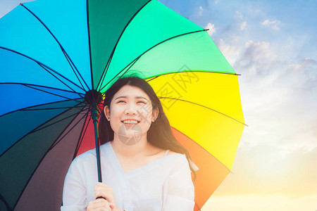 可爱的亚洲青少年在户外笑容快乐有彩虹多彩雨伞图片