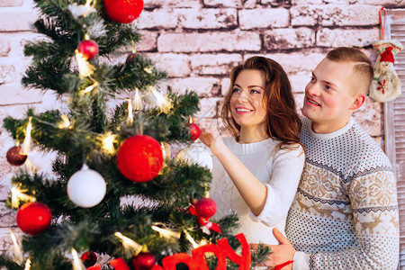 快乐的一对情侣装饰圣诞树有趣的真实情感带有文字空图片