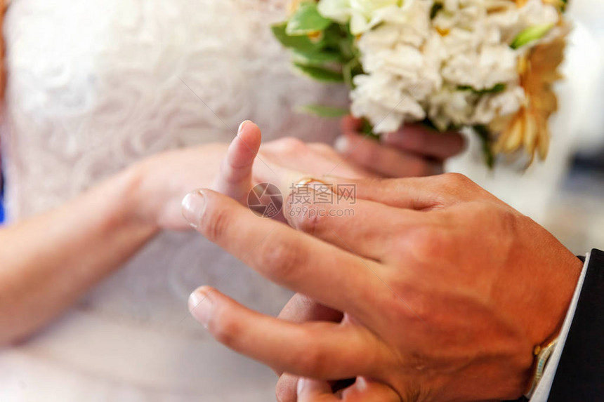 结婚戒指的手新郎的手把结婚戒指戴在图片