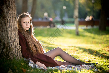 美丽的女孩在公园里坐着黑口图片