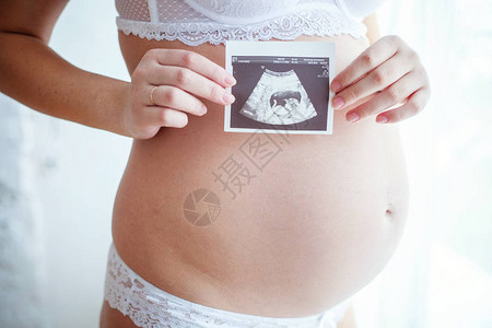 超声波和怀孕腹部的快照关闭在她的肚子上举行超声波扫描的孕妇产假怀孕柔情父母身份责背景图片