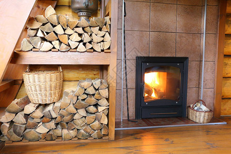 农村木屋里的柴火炉和柴火乡村房屋的一部分房间内部有一堆木柴和一个图片