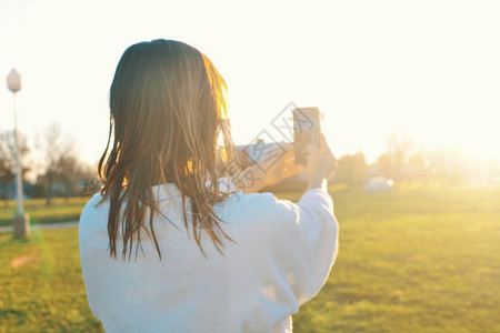 穿着浴袍的女子在日落时拍图片