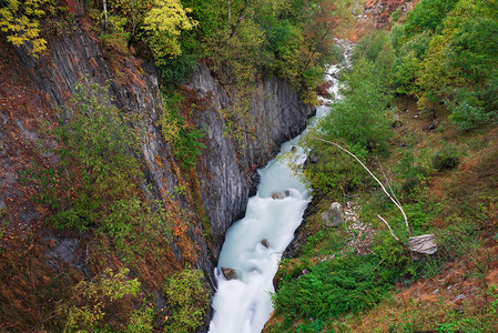 景观与峡谷中的一条河流山坡上的秋叶图片
