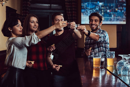 一群快乐的多种族朋友在酒吧或酒吧里站着喝伏特加高清图片