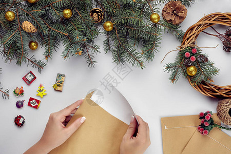 带有各种物品的圣诞桌女手将信件放在信封中顶视图片