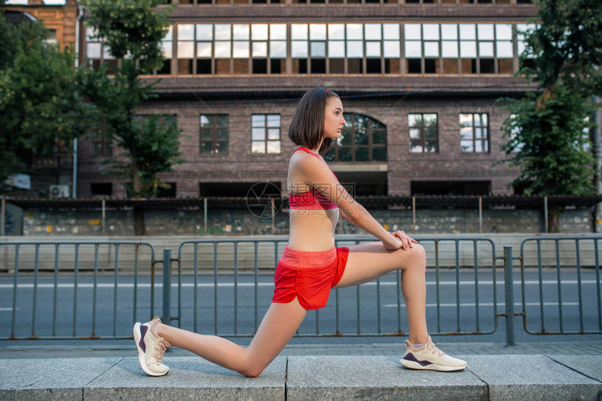 运动型女人在进行城市健身锻炼前伸展和热身双腿运动和健康的生活方式概念女运动图片