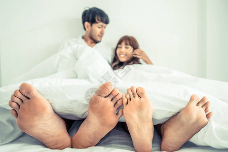 快乐的年轻夫妇在早上醒来后在家庭卧背景图片