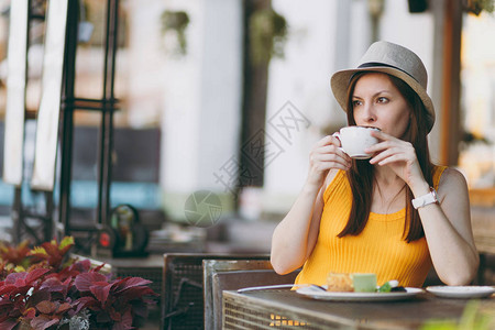 户外街头咖啡店咖啡厅的女人坐在桌边图片