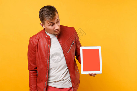 身穿红色皮夹克t恤的肖像时尚有趣的年轻人拿着平板电脑垫图片