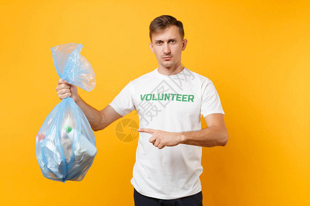 身穿T恤志愿者的男子拿着垃圾袋图片