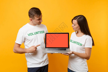 身穿白色T恤衫的男女同事一对志工持有膝上型笔记本电脑图片