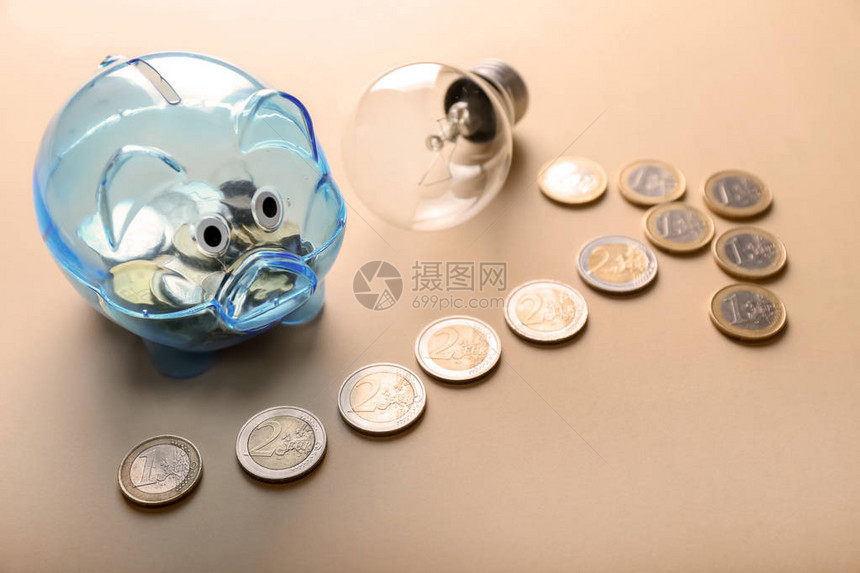 有硬币和彩色背景灯泡的小猪银行节电概念Pele图片