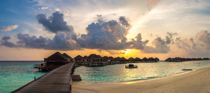 夏季傍晚在马尔代夫热带海滩的平房上方的图片